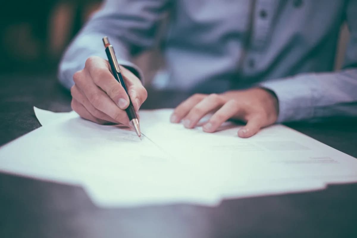 Personne signant un contrat d'assurance avec un stylo